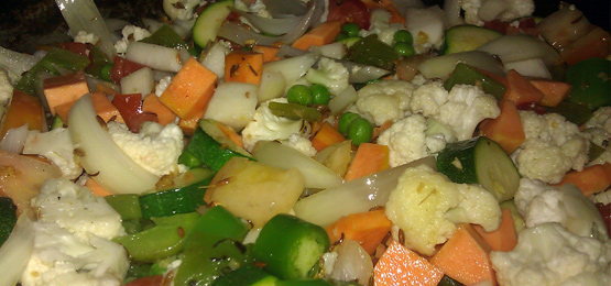 Coating the vegetables in the spices and oil